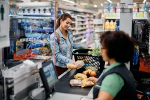 Mujer colocando los productos en la caja del supermercado.